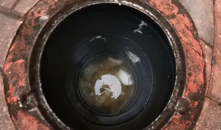 Camera view down an old sewer cleanout showing dark, standing wastewater and mineral buildup, the kind of pipe condition common in pre-1960s South Hill homes